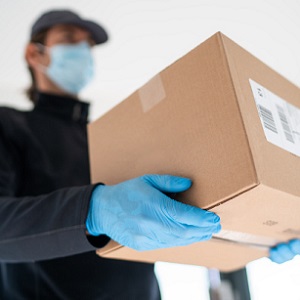 Delivery man with protective mask and gloves delivering parcels